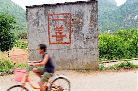 simsearch:673-08139284,k - Boy rides a bicycle past a "one good deed" sign in the countryside, Yangshuo, China Stockbilder - Premium RF Lizenzfrei, Bildnummer: 673-08139287