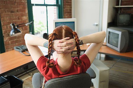 small business owner on computer not looking at camera - Red-haired woman leaning back at her office desk. Stock Photo - Premium Royalty-Free, Code: 673-02137561