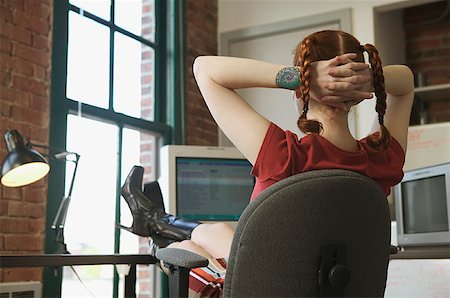 desvanes - Red-haired woman leaning back at her office desk. Foto de stock - Sin royalties Premium, Código: 673-02137562