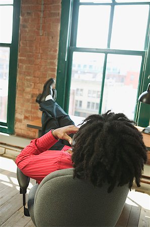 A man talking on the phone while gazing out his office window. Stock Photo - Premium Royalty-Free, Code: 673-02137585