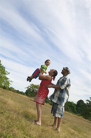 simsearch:673-02138552,k - A couple playing with their son in grassy field. Stock Photo - Premium Royalty-Free, Code: 673-02137612