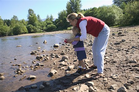 Mother helping her daughter fish. Stock Photo - Premium Royalty-Free, Code: 673-02137814