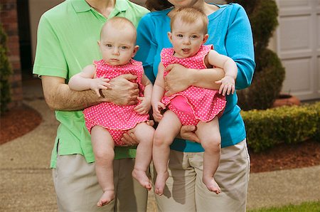 Twin babies held in their parents' arms. Stock Photo - Premium Royalty-Free, Code: 673-02137865