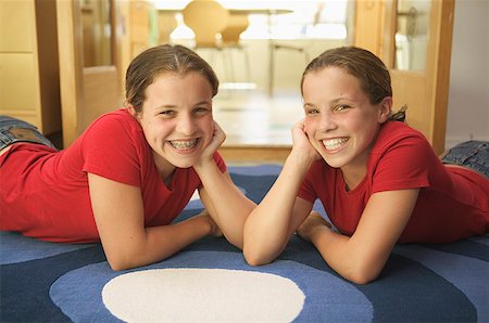 Twin teenage girls lounging on a rug. Foto de stock - Sin royalties Premium, Código: 673-02137869