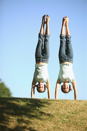 simsearch:673-02137860,k - Twin Caucasian teenage girls perform side by side handstands in the park. Stock Photo - Premium Royalty-Free, Code: 673-02137860