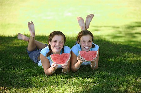 simsearch:673-02137877,k - Twin teenage girls devouring slices of watermelon. Foto de stock - Royalty Free Premium, Número: 673-02137862