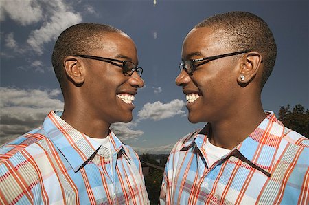 simsearch:673-02137877,k - Outdoors portrait of twin African American teenage boys in glasses and matching plaid shirts. Foto de stock - Royalty Free Premium, Número: 673-02137891