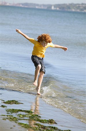 simsearch:673-02139165,k - Jeune garçon de sauter dans l'eau sur une plage. Photographie de stock - Premium Libres de Droits, Code: 673-02137924