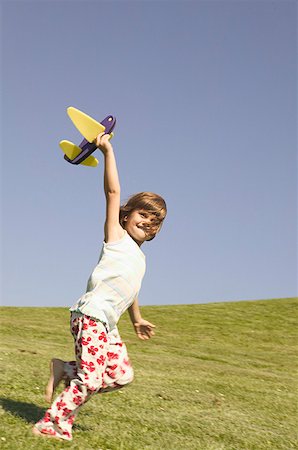 fun girls model - Young girl holding a toy airplane. Stock Photo - Premium Royalty-Free, Code: 673-02137963