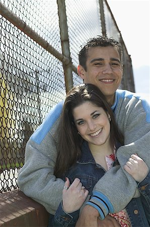 Teen couple leaning against a fence. Foto de stock - Sin royalties Premium, Código: 673-02138001