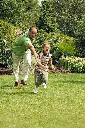 senior man chase - Grandfather playing with his young grandson at the park. Stock Photo - Premium Royalty-Free, Code: 673-02138039