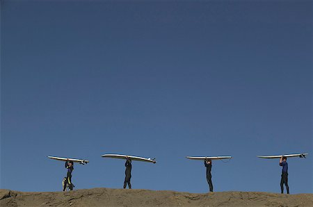 Vier Personen befördern Surfbretter auf einer Sanddüne. Stockbilder - Premium RF Lizenzfrei, Bildnummer: 673-02138086