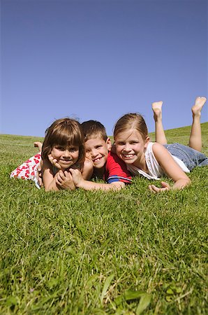 simsearch:673-02138199,k - Three children lying on grassy hillside. Stock Photo - Premium Royalty-Free, Code: 673-02138129