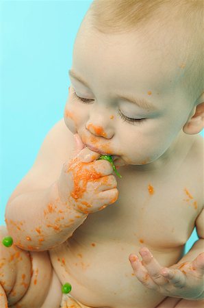 Infant eating baby food with fingers. Stock Photo - Premium Royalty-Free, Code: 673-02138132