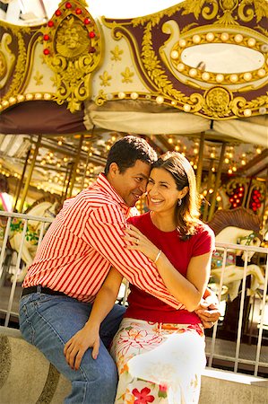 Hispanic couple in front of a carousel. Stock Photo - Premium Royalty-Free, Code: 673-02138445