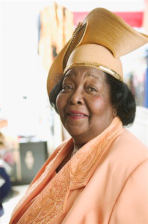elderly black woman - A senior woman wearing a yellow dress and hat. Stock Photo - Premium Royalty-Free, Code: 673-02138501