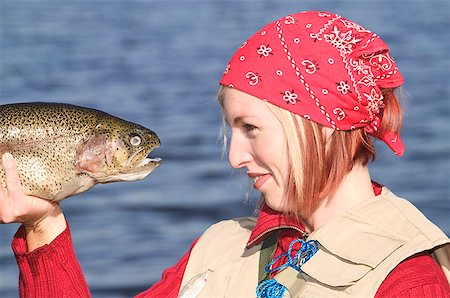 Woman going eye to eye with a large trout. Foto de stock - Sin royalties Premium, Código: 673-02138570