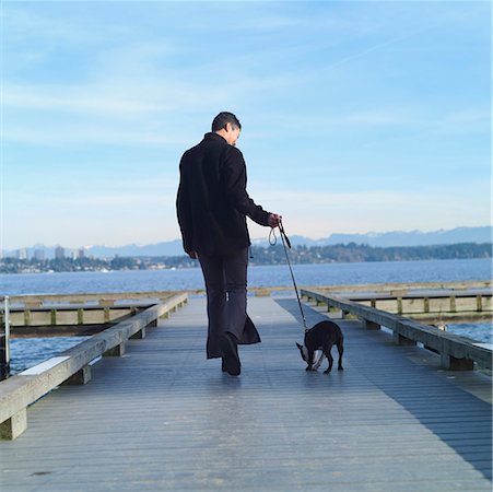 Rear view of woman walking her dog. Stock Photo - Premium Royalty-Free, Code: 673-02138583