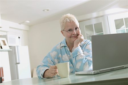 Woman working on a laptop in her pajamas. Stock Photo - Premium Royalty-Free, Code: 673-02138617