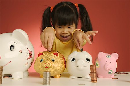 Little girl putting coins into piggy banks Fotografie stock - Premium Royalty-Free, Codice: 673-02138613