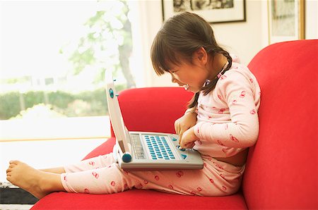 A little girl using her laptop computer Foto de stock - Sin royalties Premium, Código: 673-02138711