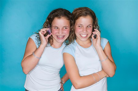 Teenaged twins using mobile phones Stock Photo - Premium Royalty-Free, Code: 673-02138726