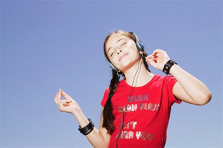 simsearch:673-02139028,k - Young girl listening to tunes through a headset Fotografie stock - Premium Royalty-Free, Codice: 673-02138753