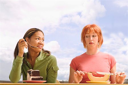 Two woman eating very different food Stock Photo - Premium Royalty-Free, Code: 673-02138774