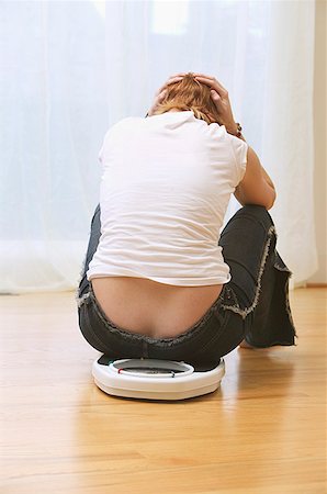 sad people on weighing scales - A woman who is unhappy about her weight Stock Photo - Premium Royalty-Free, Code: 673-02138785