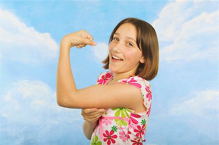 A teenaged girl flexing her muscles Stock Photo - Premium Royalty-Free, Code: 673-02138882