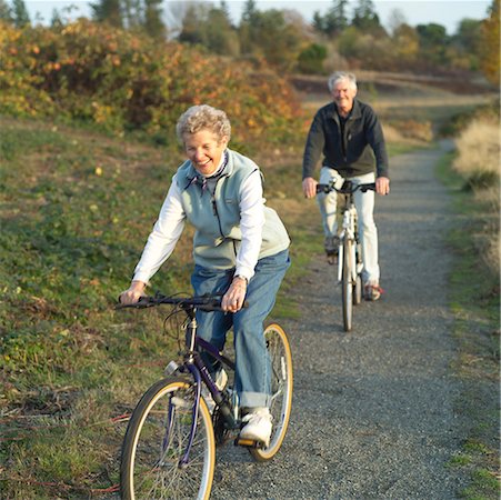 senior couple riding bicycles - Senior couple riding bikes on a trail Stock Photo - Premium Royalty-Free, Code: 673-02138883