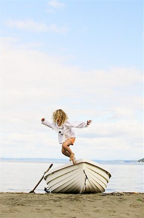 rowboat - Little girl jumping off a beached boat Stock Photo - Premium Royalty-Free, Code: 673-02139121