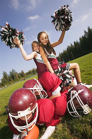 dilettante - Cheerleaders sitting on football players Fotografie stock - Premium Royalty-Free, Codice: 673-02139224