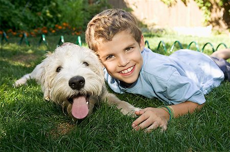 Boy and dog lying down together outdoors Fotografie stock - Premium Royalty-Free, Codice: 673-02139274