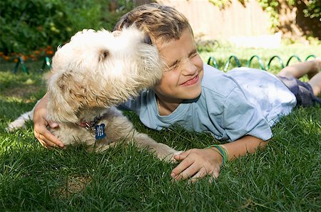 Boy and dog lying down together outdoors Fotografie stock - Premium Royalty-Free, Codice: 673-02139275