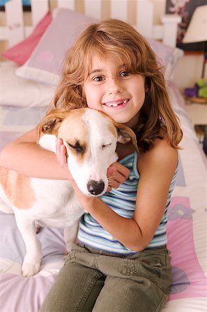 Girl hugging dog in bedroom Stock Photo - Premium Royalty-Free, Code: 673-02139288
