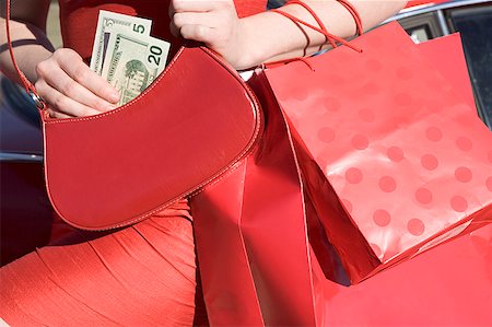 Woman holding money and shopping bags Stock Photo - Premium Royalty-Free, Code: 673-02139353