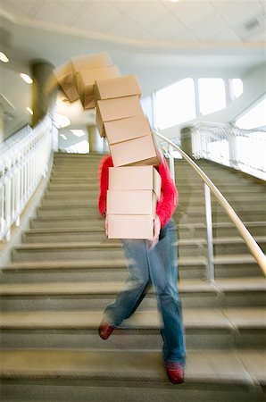 danger falling - Woman carrying boxes downstairs Stock Photo - Premium Royalty-Free, Code: 673-02139444