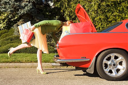 Woman looking in trunk of car Stock Photo - Premium Royalty-Free, Code: 673-02139455