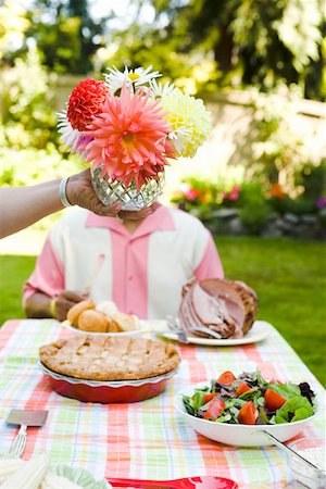 Flower centerpiece held above picnic table Stock Photo - Premium Royalty-Free, Code: 673-02139572