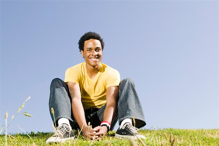 Young man sitting outdoors Stock Photo - Premium Royalty-Free, Code: 673-02139786