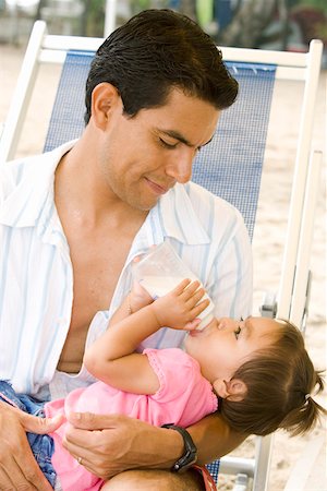 Dad holding daughter drinking from bottle Stock Photo - Premium Royalty-Free, Code: 673-02139964
