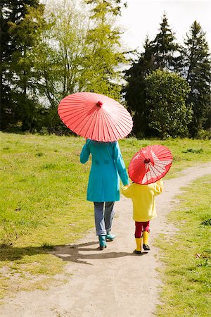 sharing umbrella - Mother and daughter walking with parasols Stock Photo - Premium Royalty-Free, Code: 673-02140039