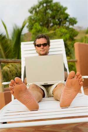 Barefoot man using laptop outside Stock Photo - Premium Royalty-Free, Code: 673-02140104