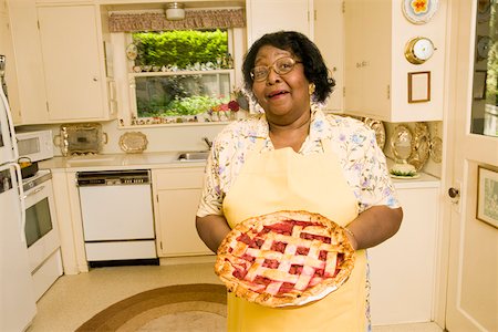 elderly black woman indoors - Portrait of woman holding homemade pie Stock Photo - Premium Royalty-Free, Code: 673-02140260
