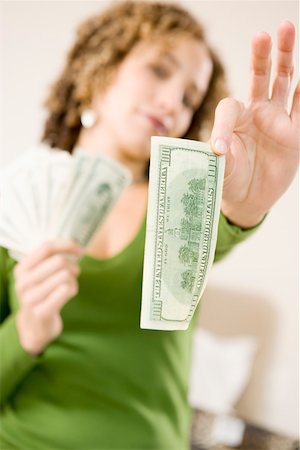 Woman holding a hundred dollar bill Stock Photo - Premium Royalty-Free, Code: 673-02140326