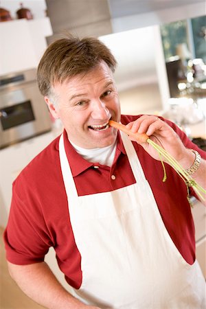simsearch:673-02140337,k - Man in apron biting into carrot Stock Photo - Premium Royalty-Free, Code: 673-02140406