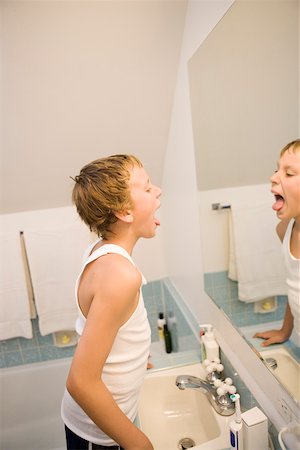 simsearch:673-02140507,k - Boy looking at tongue in bathroom mirror Foto de stock - Royalty Free Premium, Número: 673-02140502