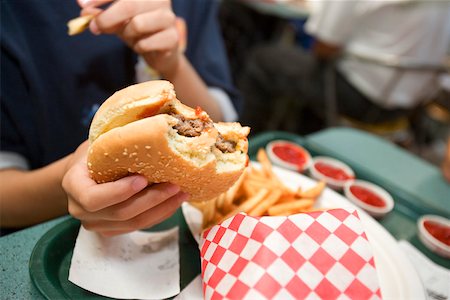French fries et burger dans la main du garçon Photographie de stock - Premium Libres de Droits, Code: 673-02140514