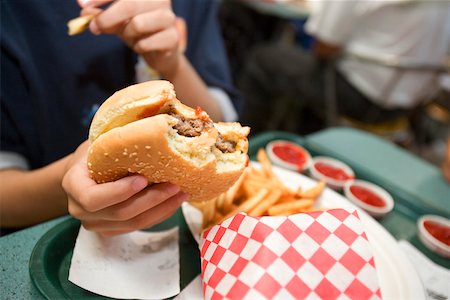 fast food restaurant inside - French fries and burger in boy's hand Stock Photo - Premium Royalty-Free, Code: 673-02140514